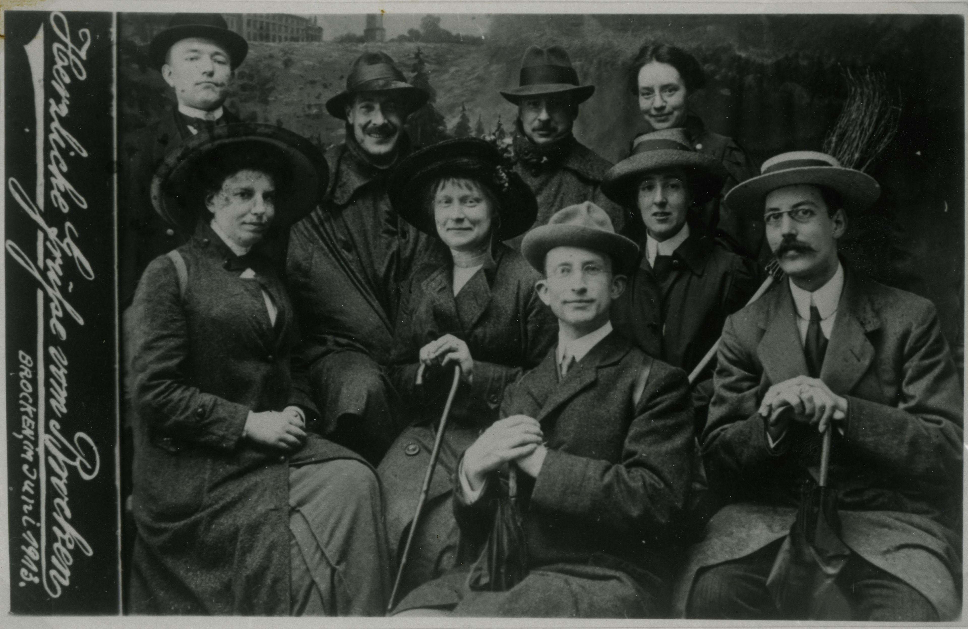Portret van negen zittende personen, mannen en vrouwen, uit 1913