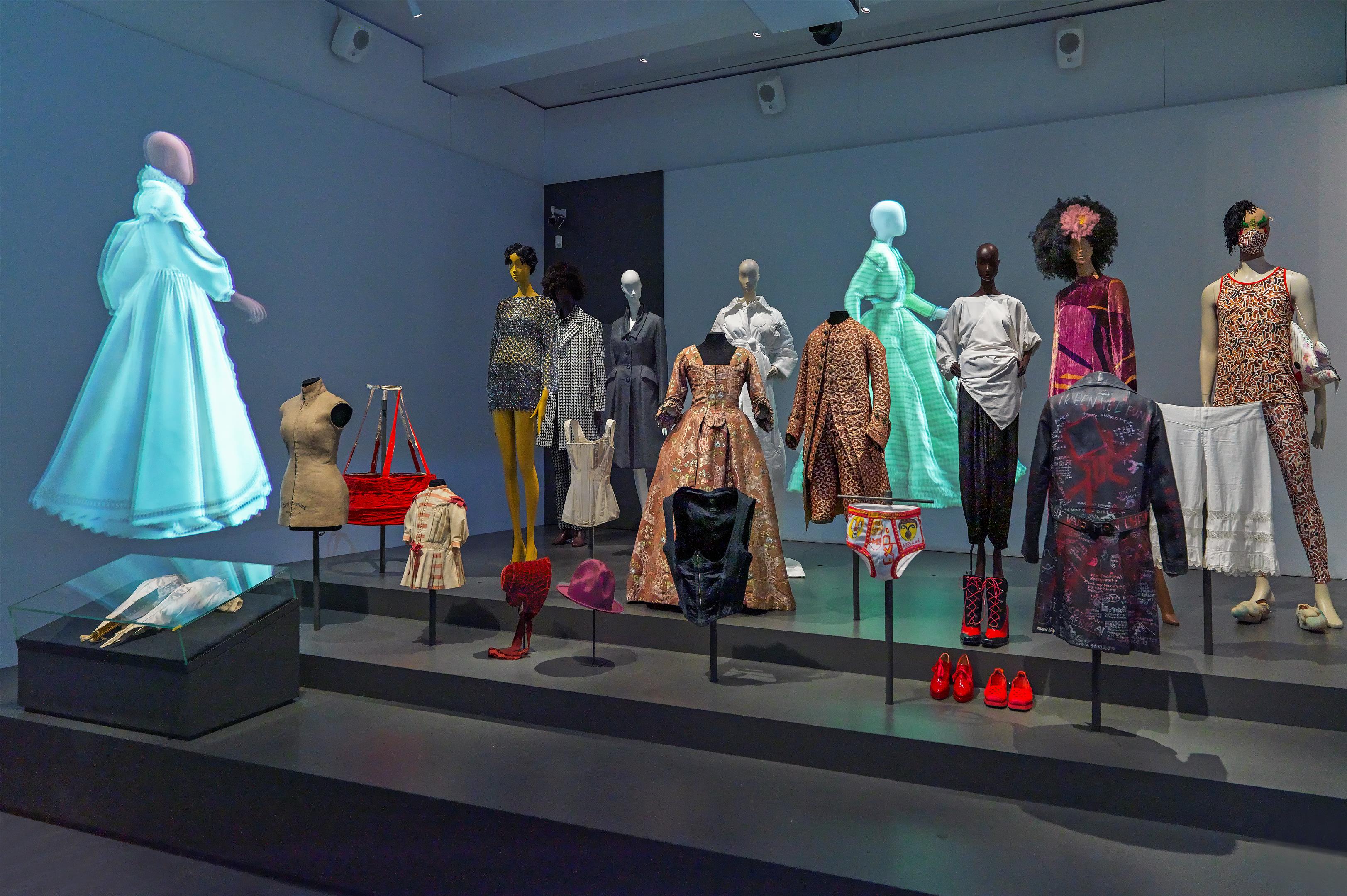 Verschillende kledingstukken gespresenteerd in een museumzaal